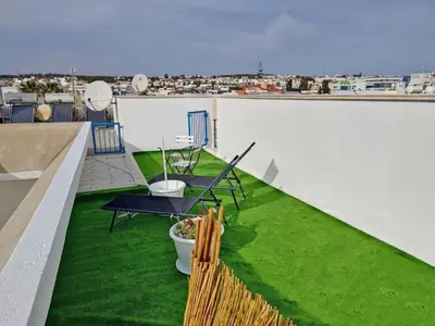 a patio with green grass on the roof of a building at Napa blue Nissi beach apartments in Ayia Napa