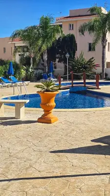 a vase with a plant in it next to a pool at Sunny Pyla Escape with Pool, Tennis & Fast Wi-Fi in Pyla