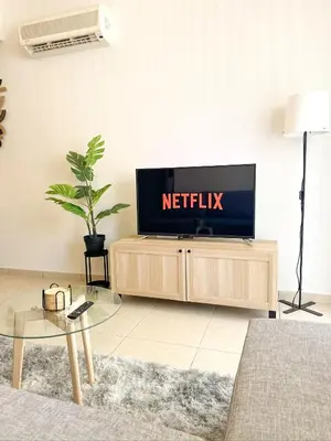 a living room with a television on a tv stand at Sunny Pyla Escape with Pool, Tennis & Fast Wi-Fi in Pyla