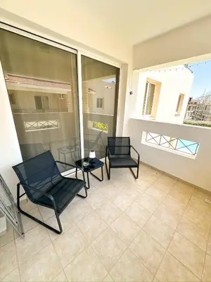 two chairs and a table on a balcony at Sunny Pyla Escape with Pool, Tennis & Fast Wi-Fi in Pyla