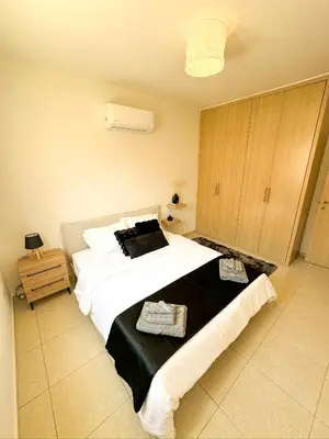 a bedroom with a large bed with white sheets at Sunny Pyla Escape with Pool, Tennis & Fast Wi-Fi in Pyla