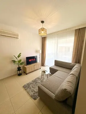 a living room with a couch and a tv at Sunny Pyla Escape with Pool, Tennis & Fast Wi-Fi in Pyla