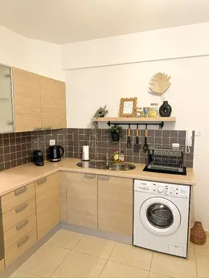 a kitchen with a sink and a washing machine at Sunny Pyla Escape with Pool, Tennis & Fast Wi-Fi in Pyla