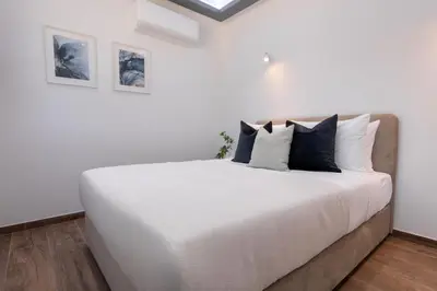 a bedroom with a large white bed with pillows at Palaiomylos Forest Residence