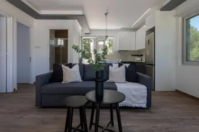 a living room with a blue couch and a table at Palaiomylos Forest Residence