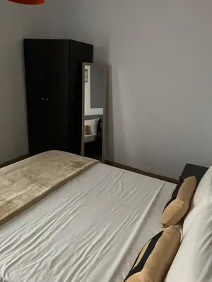 a bedroom with a bed and a black cabinet at Panos salt lake apartment in Aglantzia