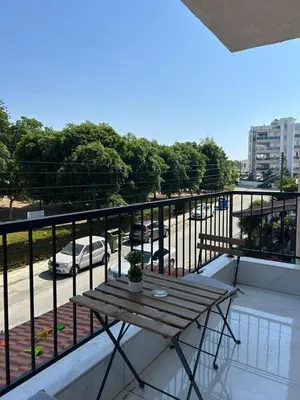 a wooden table on the balcony of a building at Modern 3BR Family Apartment in Quiet Drosia with Balcony in Larnaka