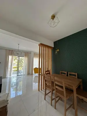 a dining room with a table and a green wall at Modern 3BR Family Apartment in Quiet Drosia with Balcony in Larnaka