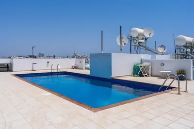 a swimming pool on the roof of a building at Stylish 2BR Apartment with Rooftop Pool in Mackenzie in Larnaka