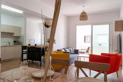 a kitchen and living room with a table and chairs at Stylish 2BR Apartment with Rooftop Pool in Mackenzie in Larnaka