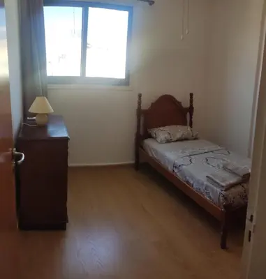 a bedroom with a bed and a dresser and a window at Poseidon 502 penthouse in Larnaka