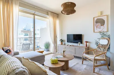 a living room with a couch and a tv at Mystique 1-Bedroom Apartment in Larnaka