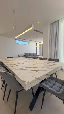 a large marble table in a room with chairs at Aqua Beachfront Villas - Villa 1 in Ayia Napa