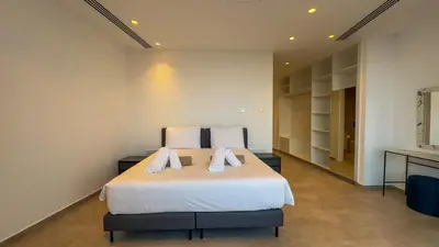 a bedroom with a large white bed with white pillows at Aqua Beachfront Villas - Villa 1 in Ayia Napa