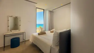 a bedroom with a bed and a mirror and a window at Aqua Beachfront Villas - Villa 1 in Ayia Napa