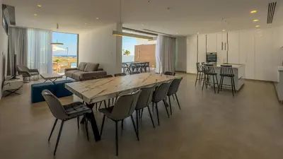 a living room with a large table and chairs at Aqua Beachfront Villas - Villa 2 in Ayia Napa