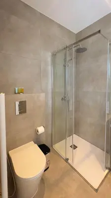 a bathroom with a toilet and a glass shower at Aqua Beachfront Villas - Villa 2 in Ayia Napa