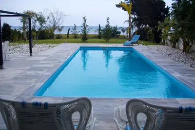 a swimming pool with two chairs and a table at Katerina House in Pervolia