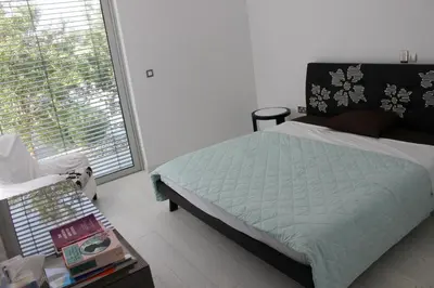 a bedroom with a bed and a large window at Katerina House in Pervolia