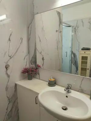 a white bathroom with a sink and a mirror at Possidon Beach Getaway in Meneou