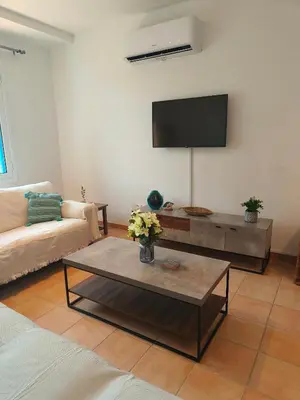 a living room with a couch and a tv at Possidon Beach Getaway in Meneou