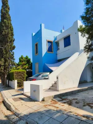 a blue house with stairs in front of it at Possidon Beach Getaway in Meneou