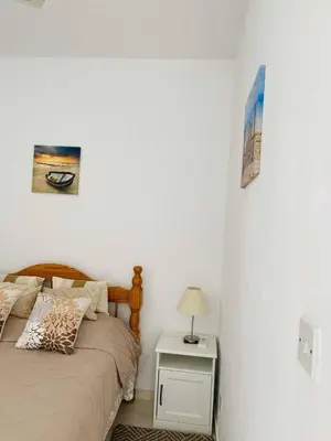 a bedroom with a bed and a side table with a lamp at Ikaria Village, Maisonette Sea 10 in Aglantzia
