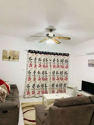 a living room with a couch and a ceiling fan at Ikaria Village, Maisonette Sea 10 in Aglantzia