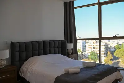 a bedroom with a large bed with two towels on it at The 1 -Nicosia Luxe Stay- Gym Pool 24h Concierge in Nicosia