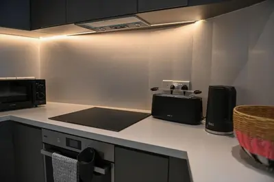 a kitchen with a counter top with a toaster and a microwave at The 1 -Nicosia Luxe Stay- Gym Pool 24h Concierge in Nicosia