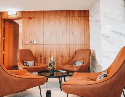 a waiting room with orange chairs and a table at The 1 -Nicosia Luxe Stay- Gym Pool 24h Concierge in Nicosia