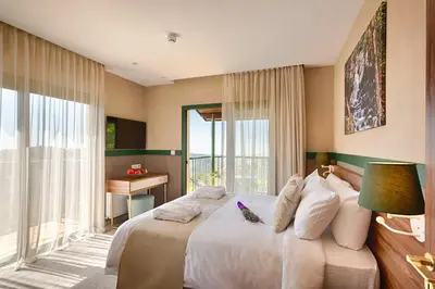 a bedroom with a large white bed with a window at Petit Palais Platres Boutique Hotel in Platres
