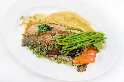 a white plate of food with meat and vegetables at Petit Palais Platres Boutique Hotel in Platres