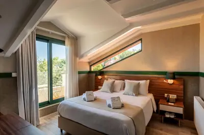a bedroom with a large bed with a window at Petit Palais Platres Boutique Hotel in Platres