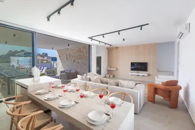a dining room and living room with a table and chairs at Orea Luxury Villas in Ayia Napa