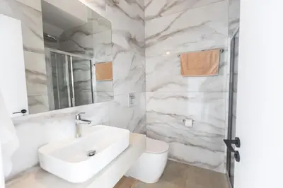 a white bathroom with a sink and a toilet at Orea Luxury Villas in Ayia Napa
