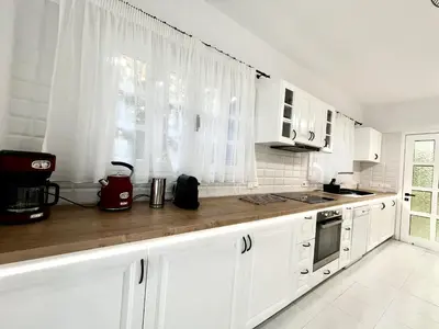 a white kitchen with white cabinets and a window at STAY Cavo Bay Villa in Protaras