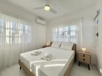a white bedroom with a bed with two towels on it at STAY Cavo Bay Villa in Protaras