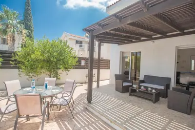 a patio with a table and chairs and a television at Mandali Villa in Protaras