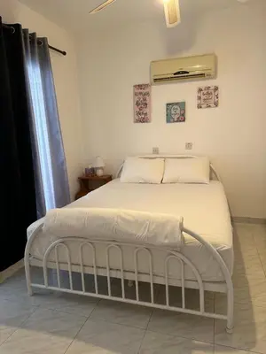 a white bed in a room with a window at Sunny house in Larnaka