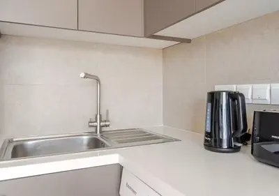 a kitchen with a sink and a coffee maker at Urban Bay Limassol in Limassol