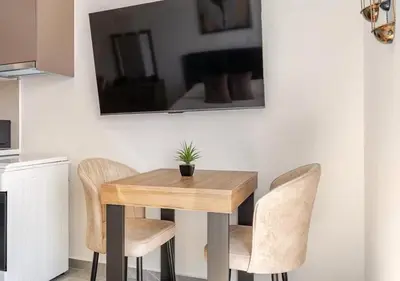 a wooden table with two chairs and a potted plant on it at Urban Bay Limassol in Limassol