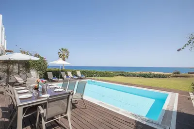 a patio with a table and chairs next to a swimming pool at Beachfront villa close to Protaras, 1271 in Protaras