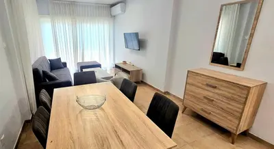 a living room with a wooden table and a living room with a couch at Rita Seaview - Agios Tychonas Four Seasons Area in Limassol