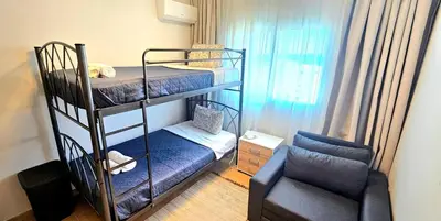 a small room with two bunk beds and a chair at Rita Seaview - Agios Tychonas Four Seasons Area in Limassol