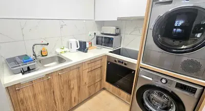 a small kitchen with a washer and a sink at Rita Seaview - Agios Tychonas Four Seasons Area in Limassol