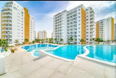 a swimming pool in the middle of some buildings at Bedroom flat Caesar resort, Iskele north Cyprus in Vrysoules