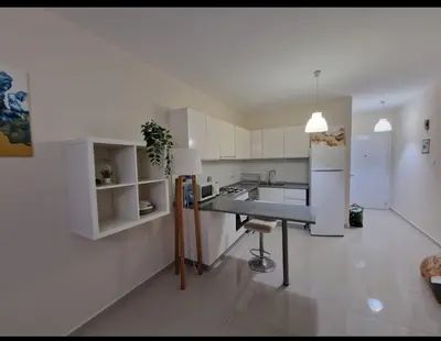 a kitchen with white cabinets and a table in it at Bedroom flat Caesar resort, Iskele north Cyprus in Vrysoules