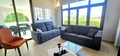 a living room with two couches and a table at Agia Thekla bungalow with pool in Ayia Napa
