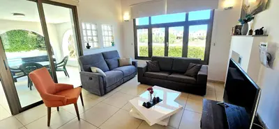 a living room with two couches and a tv at Agia Thekla bungalow with pool in Ayia Napa